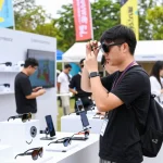 Engaged professional testing smart glasses at an outdoor tech festival showcasing innovative features and vibrant engagement.